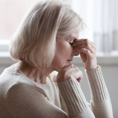 tired senior female caregiver with eyes closes 