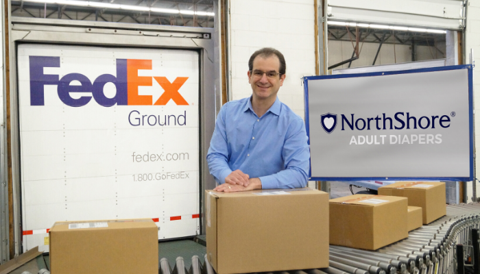 NorthShore Founder, Adam Greenberg with packages in Buffalo Grove, Illinois warehouse near Fedex truck 