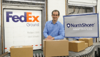 Founder Adam Greenberg with Fedex truck and adult diapers sign