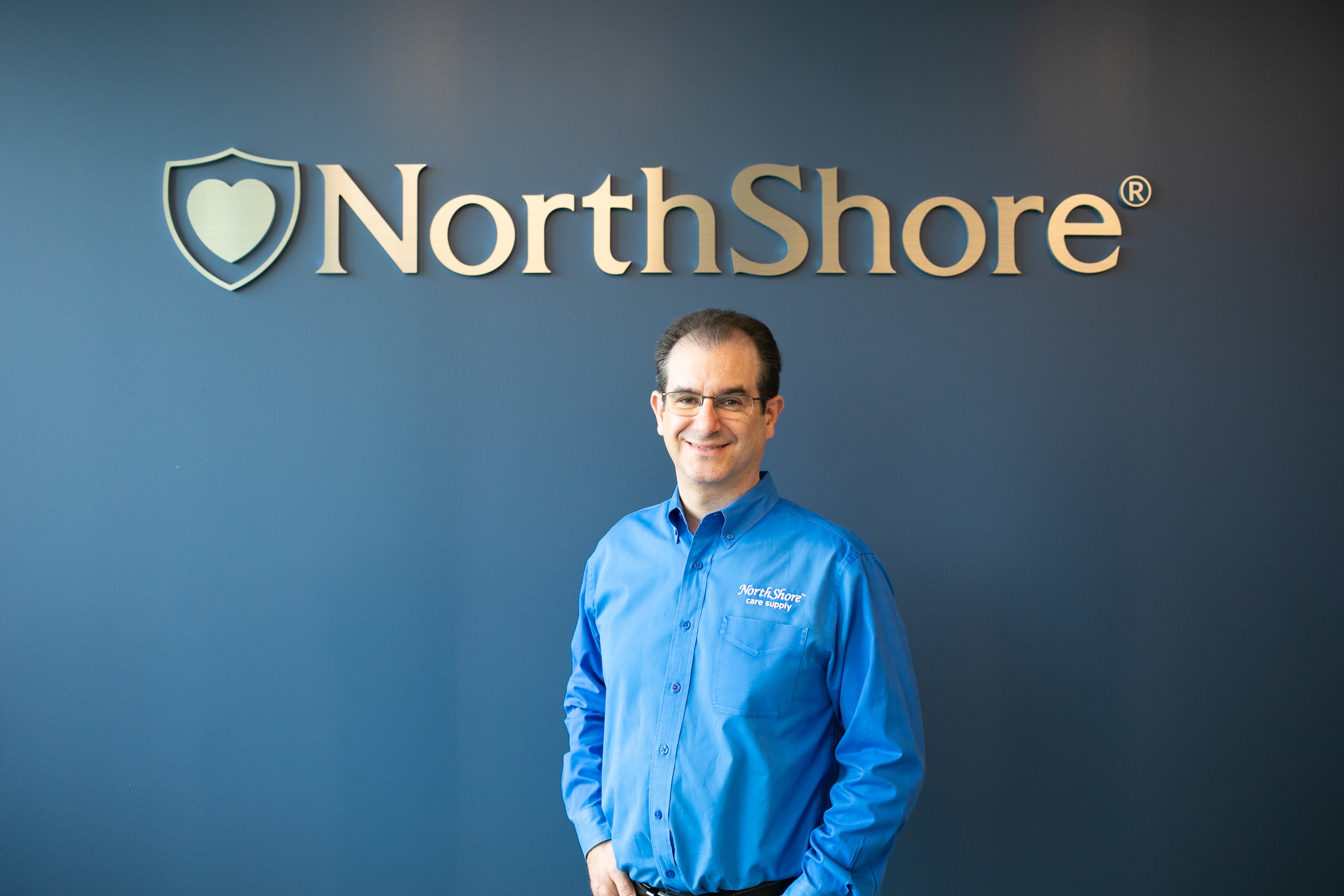 Founder, Adam Greenberg in front of NorthShore interior sign
