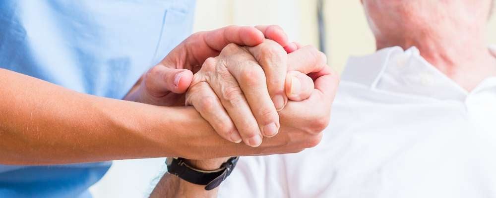 caregiver holding patients hand