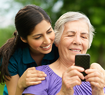 young woman and senior woman looking at a mobile device